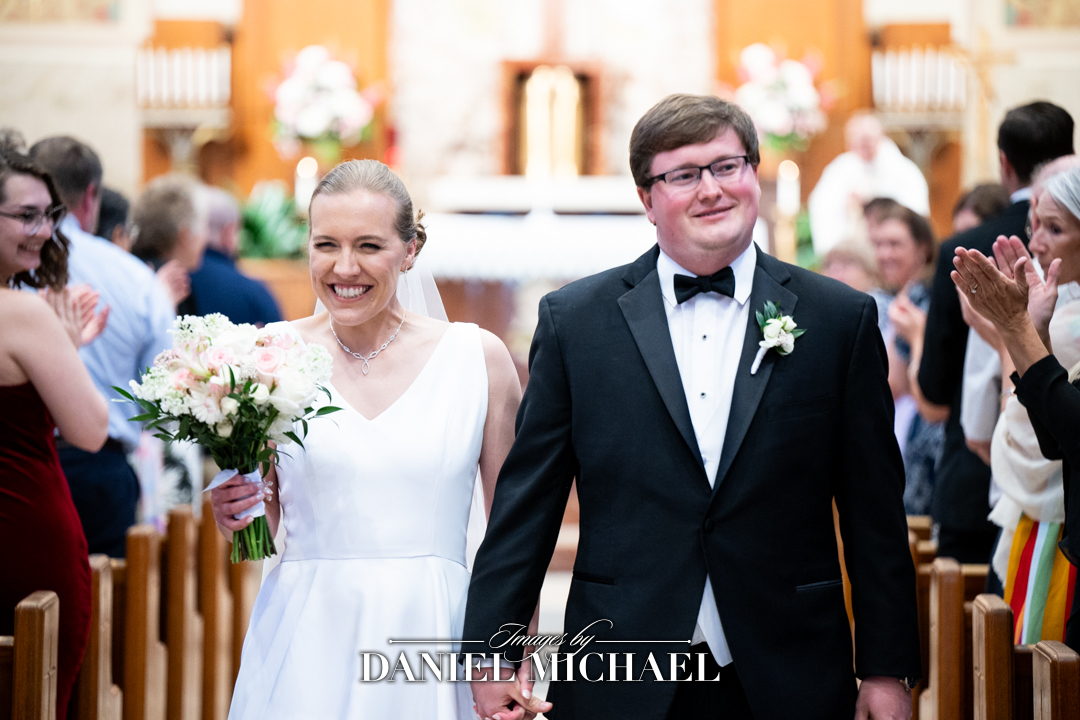 Bride walking with Groom down aisle smiling